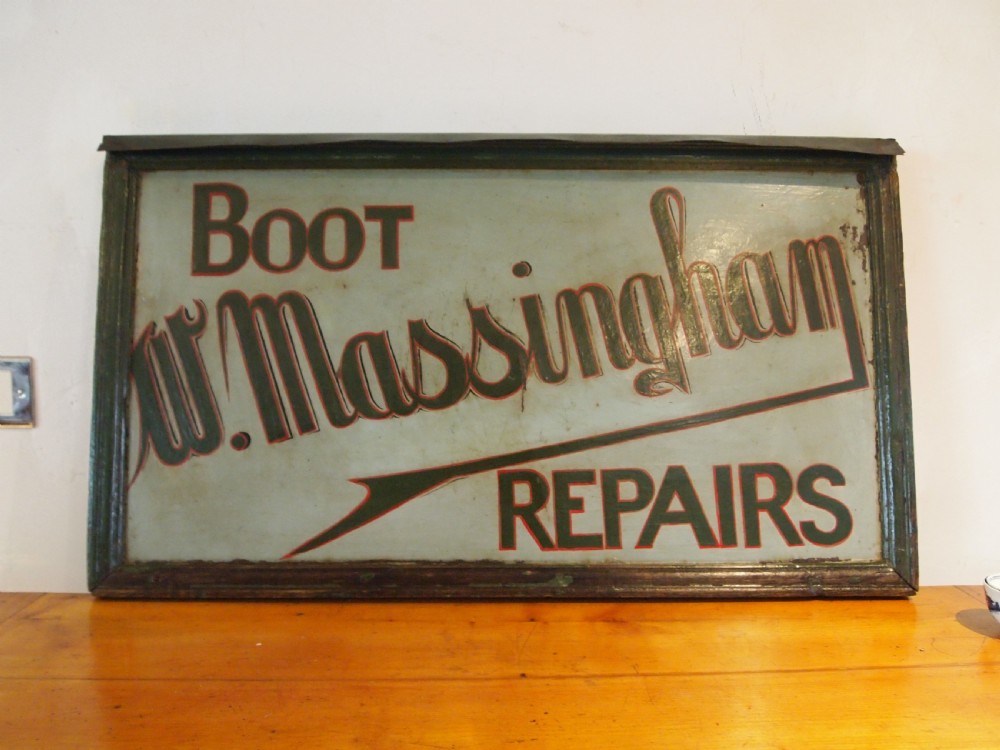 A rectangular hand-painted antique metal shop sign featuring black lettering outlined in red reading Boot W Massingham Repairs against a grey background within a dark metal frame. View XIII