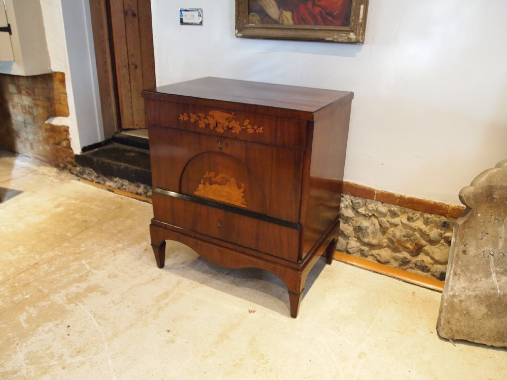 A warm brown Italian timber commode featuring decorative botanical marquetry inlays, two drawers, and square tapered feet.