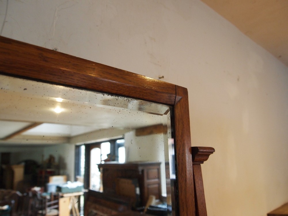 An Arts and Crafts solid oak dressing table featuring a central tall mirror flanked by two side cupboards with decorative inlaid landscape panels and metal strap hinges. View XII