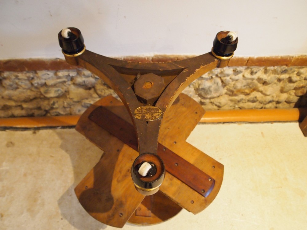 A circular Victorian burr walnut revolving library table featuring parcel gilt detailing, a turned pedestal base, and lower gallery shelves. View VIII