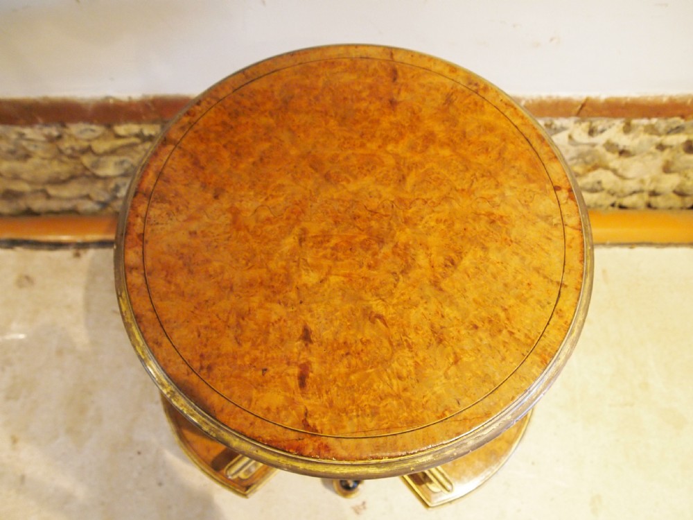 A circular Victorian burr walnut revolving library table featuring parcel gilt detailing, a turned pedestal base, and lower gallery shelves. View XI