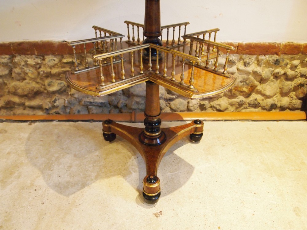 A circular Victorian burr walnut revolving library table featuring parcel gilt detailing, a turned pedestal base, and lower gallery shelves. View XII