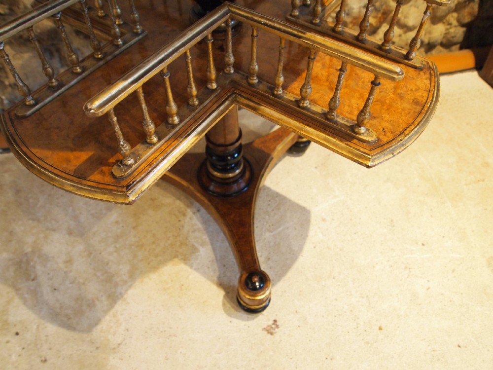 A circular Victorian burr walnut revolving library table featuring parcel gilt detailing, a turned pedestal base, and lower gallery shelves. View XIV
