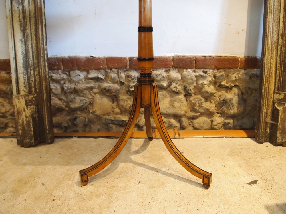 An octagonal Regency satinwood tilt-top table featuring hand-painted floral artwork on a slender turned column and tripod base. View II