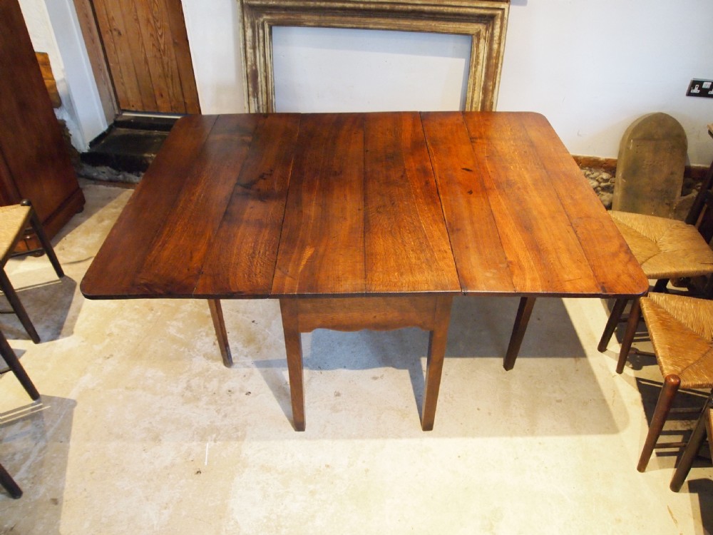 An 18th-century George III Welsh oak drop-leaf dining table with square tapered legs and a shaped apron. View V