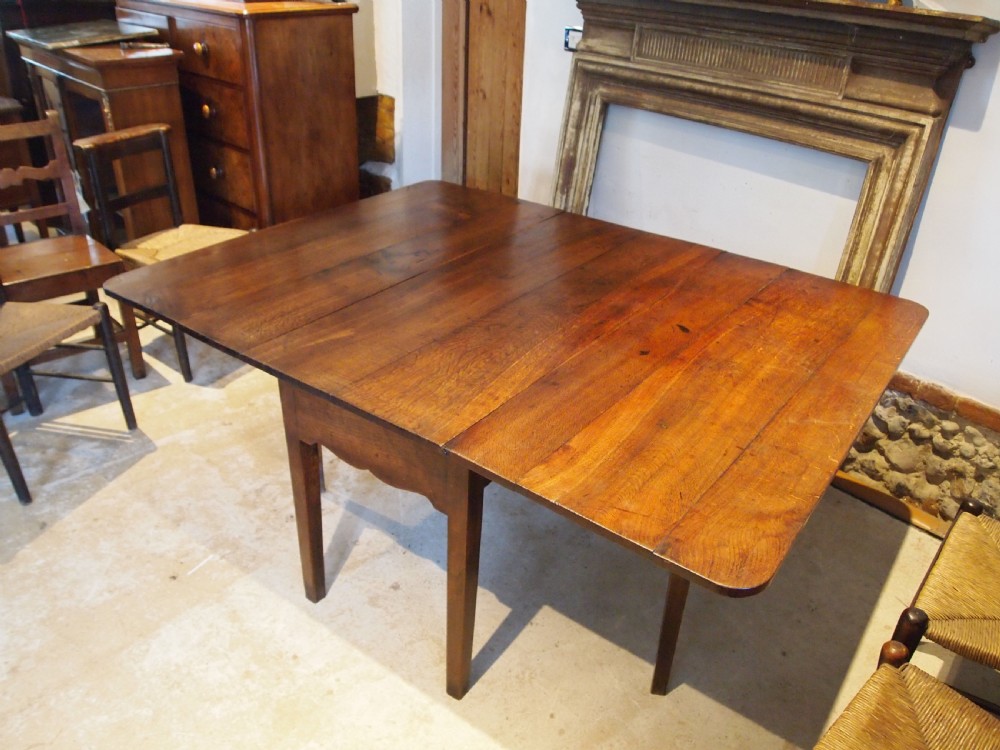 An 18th-century George III Welsh oak drop-leaf dining table with square tapered legs and a shaped apron. View VI