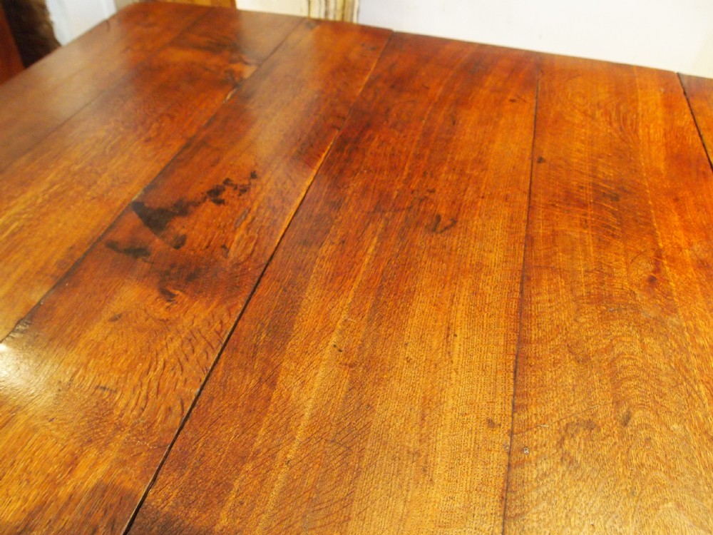 An 18th-century George III Welsh oak drop-leaf dining table with square tapered legs and a shaped apron. View VIII