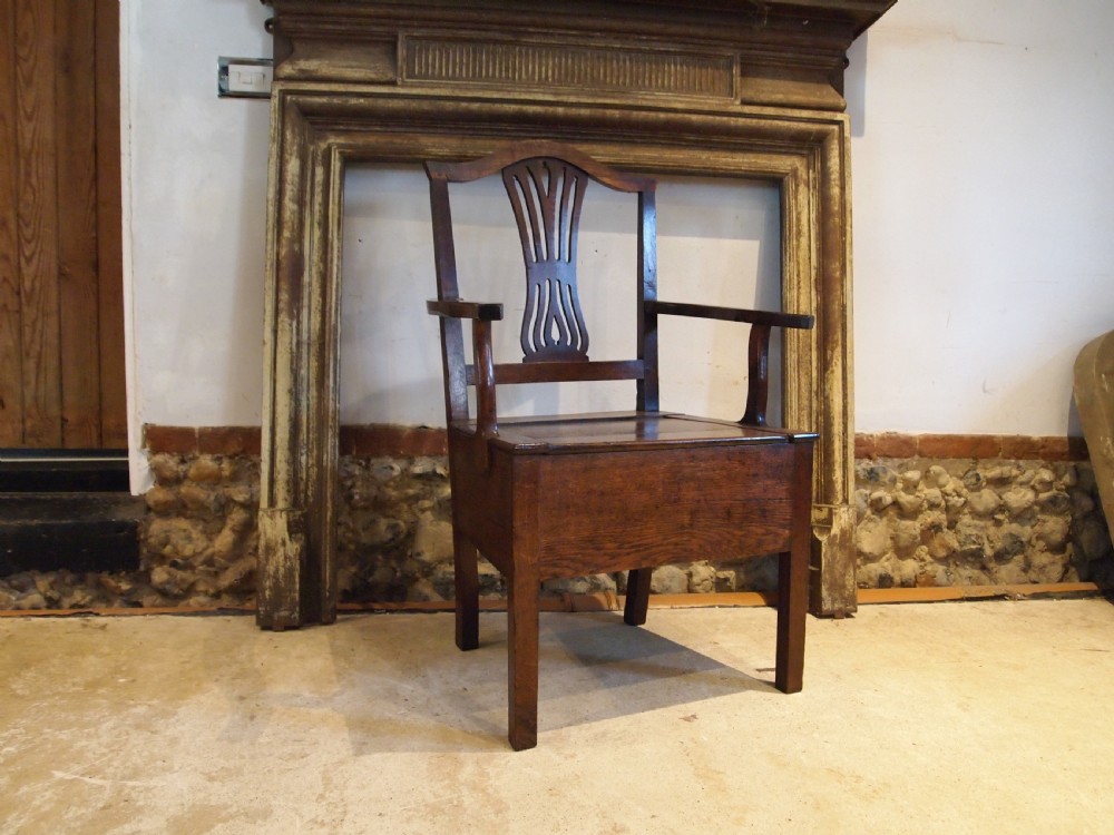 A George III Welsh oak commode armchair featuring a pierced back splat, shaped armrests, square legs, and an enclosed box seat base. View II
