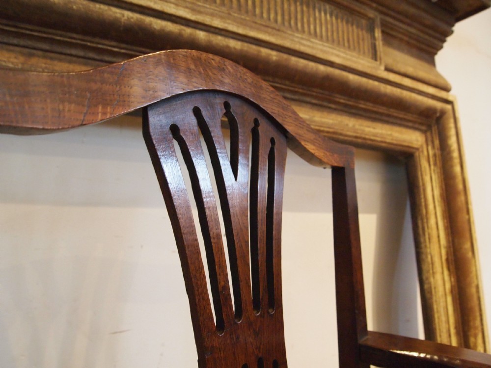 A George III Welsh oak commode armchair featuring a pierced back splat, shaped armrests, square legs, and an enclosed box seat base. View III