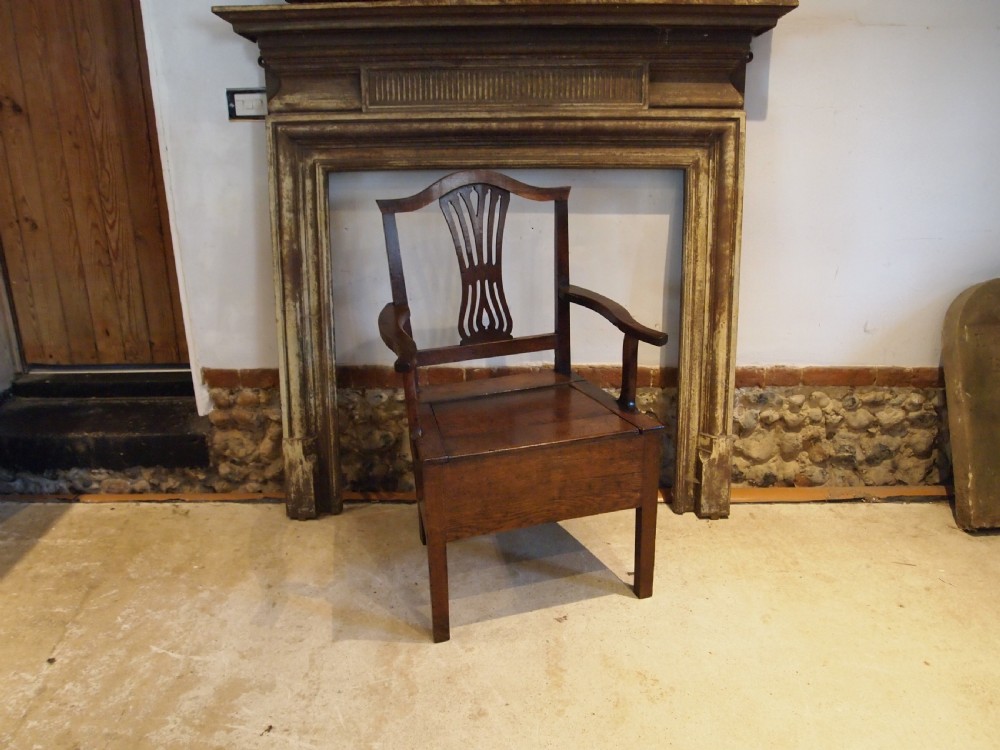 A George III Welsh oak commode armchair featuring a pierced back splat, shaped armrests, square legs, and an enclosed box seat base. View V