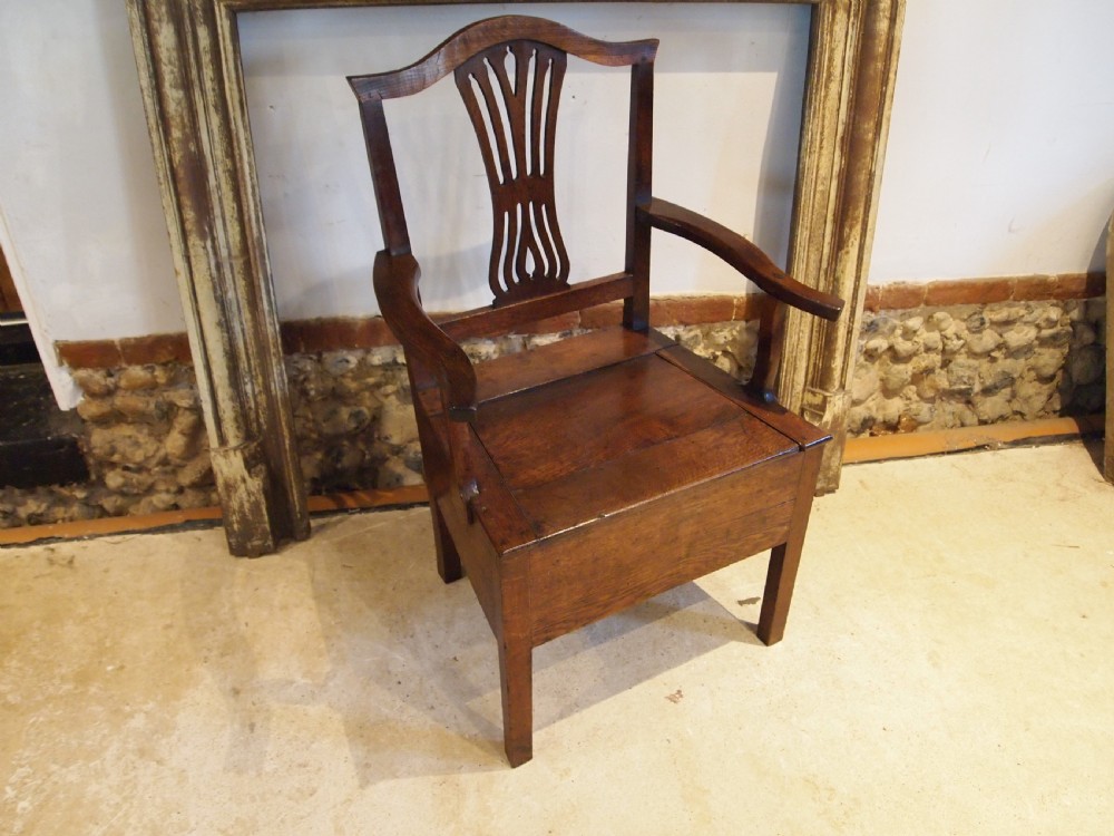 A George III Welsh oak commode armchair featuring a pierced back splat, shaped armrests, square legs, and an enclosed box seat base. View VII