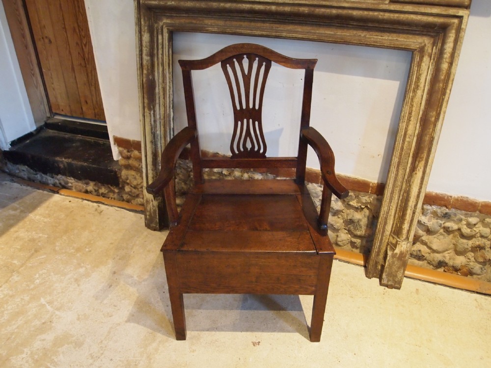 A George III Welsh oak commode armchair featuring a pierced back splat, shaped armrests, square legs, and an enclosed box seat base. View VIII