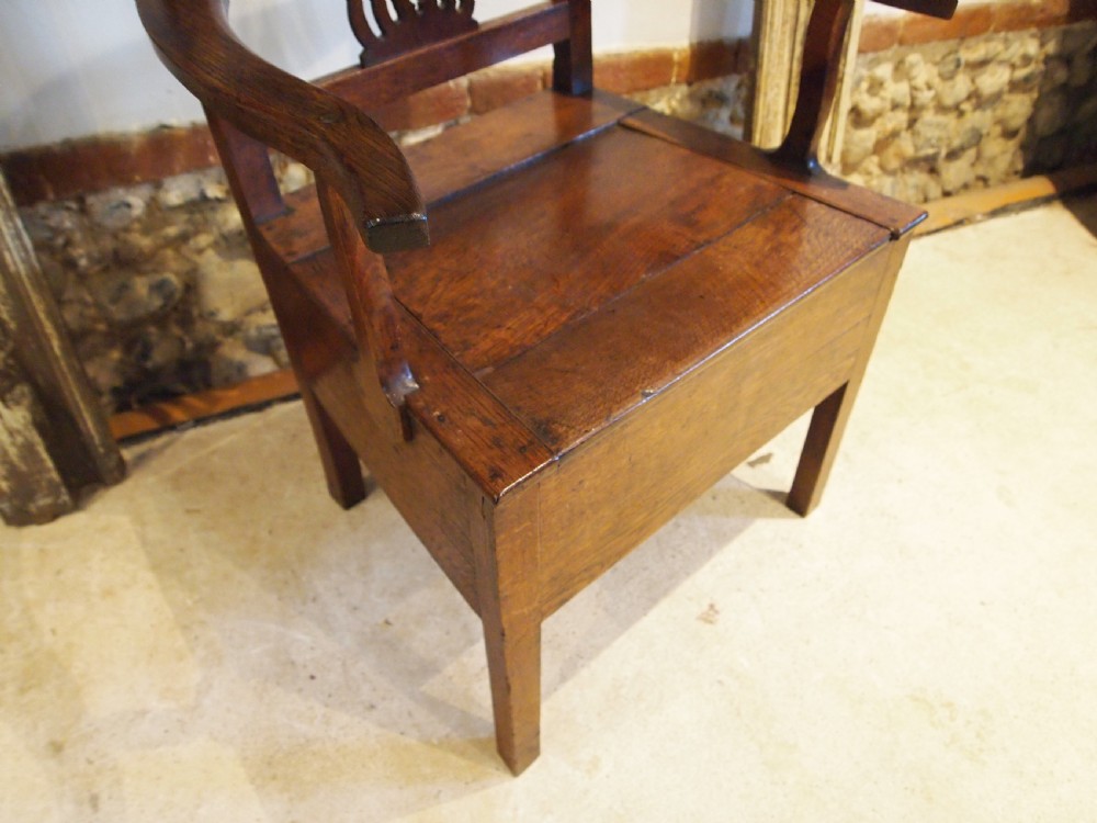 A George III Welsh oak commode armchair featuring a pierced back splat, shaped armrests, square legs, and an enclosed box seat base. View IX