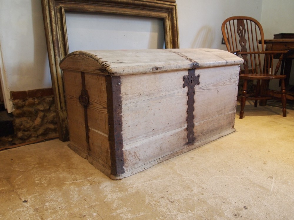 An eighteenth-century Scandinavian pine marriage chest featuring a domed lid, wrought iron corner brackets, and a central decorative iron escutcheon plate.