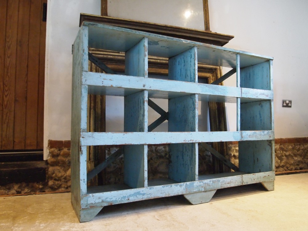 A late 19th-century open wooden storage unit featuring twelve cubby compartments finished in distressed light blue paint.