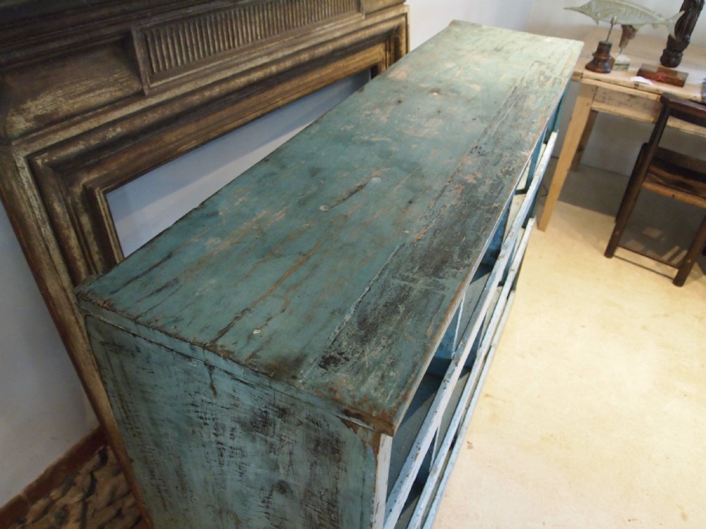 A late 19th-century open wooden storage unit featuring twelve cubby compartments finished in distressed light blue paint. View III