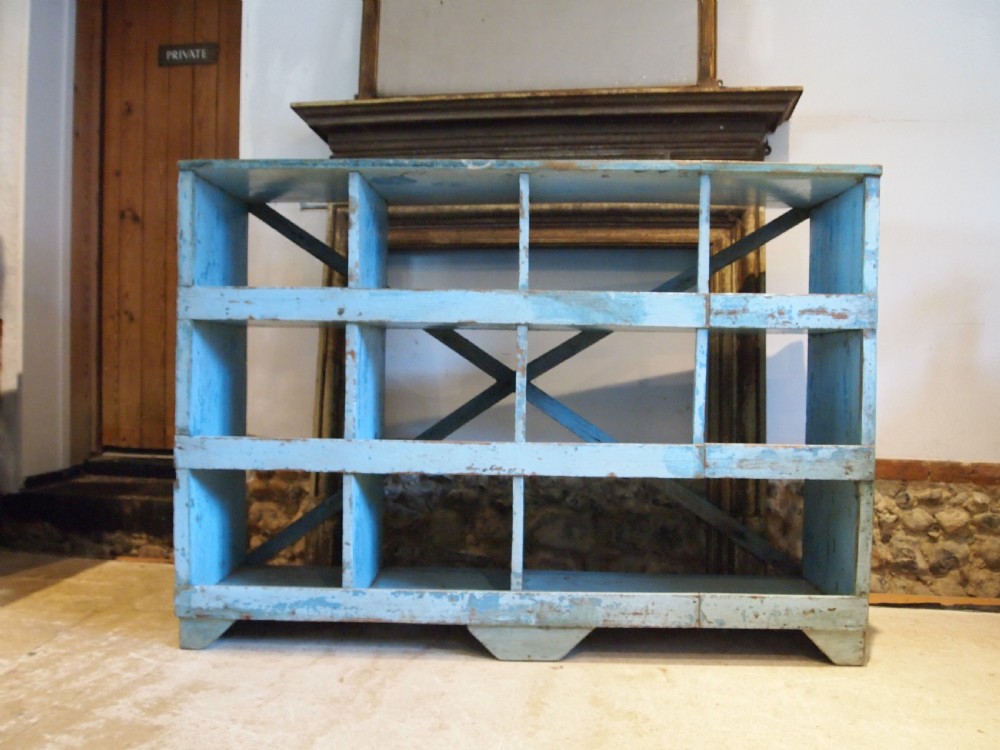 A late 19th-century open wooden storage unit featuring twelve cubby compartments finished in distressed light blue paint. View VI