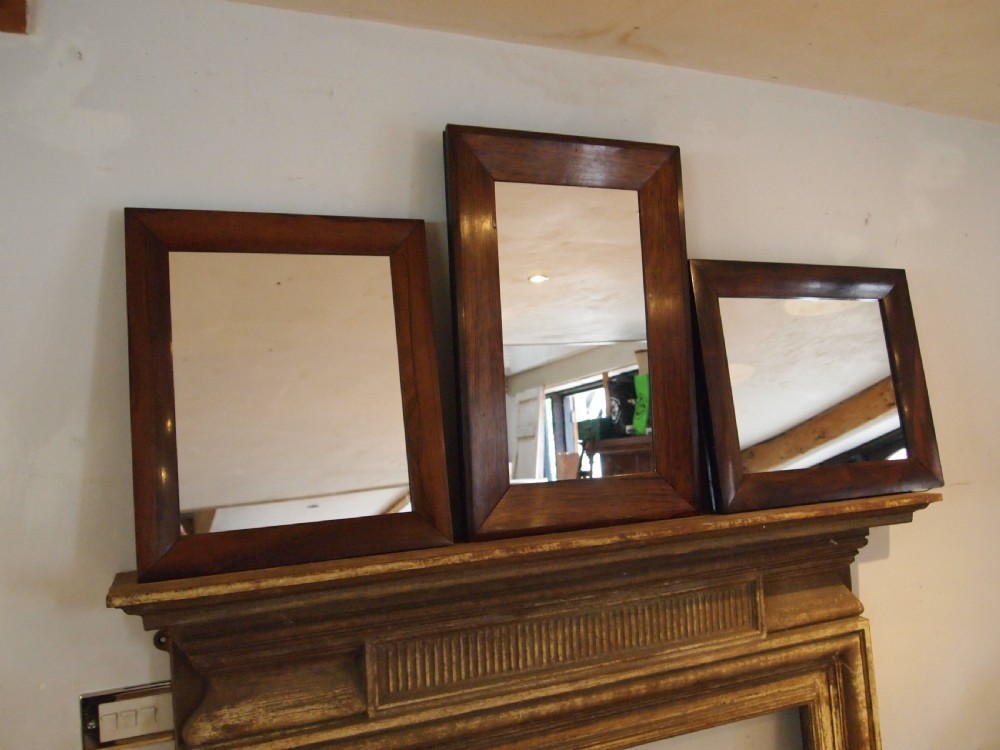 A trio of rectangular Regency period mirrors featuring dark rosewood frames with wide moulded borders. View V