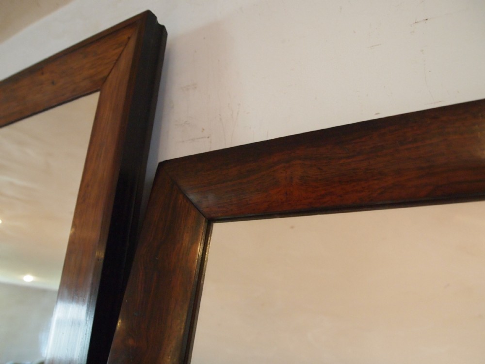 A trio of rectangular Regency period mirrors featuring dark rosewood frames with wide moulded borders. View X