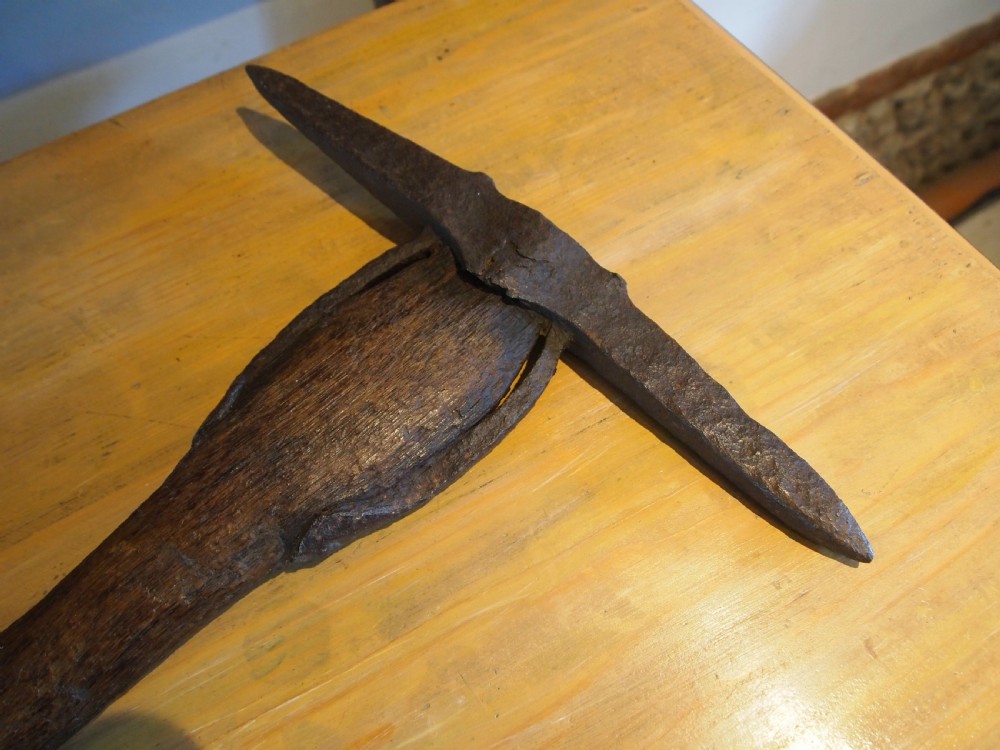 An antique nineteenth-century miners pickaxe with a dark turned wooden handle and a hand-forged iron head. View VIII