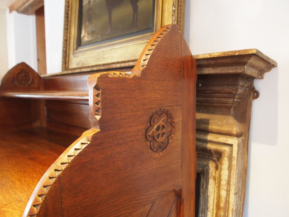 A Victorian oak chest of drawers featuring an upper gallery shelf, seven drawers with ornate brass drop handles, and planked sides. View II