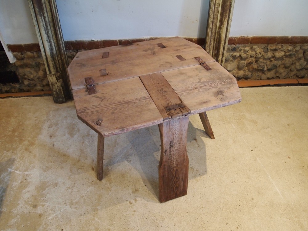 A George III primitive pine chair table featuring a tall central wooden backboard splat, flat bench seat, iron hinges, and four splayed round legs. View II