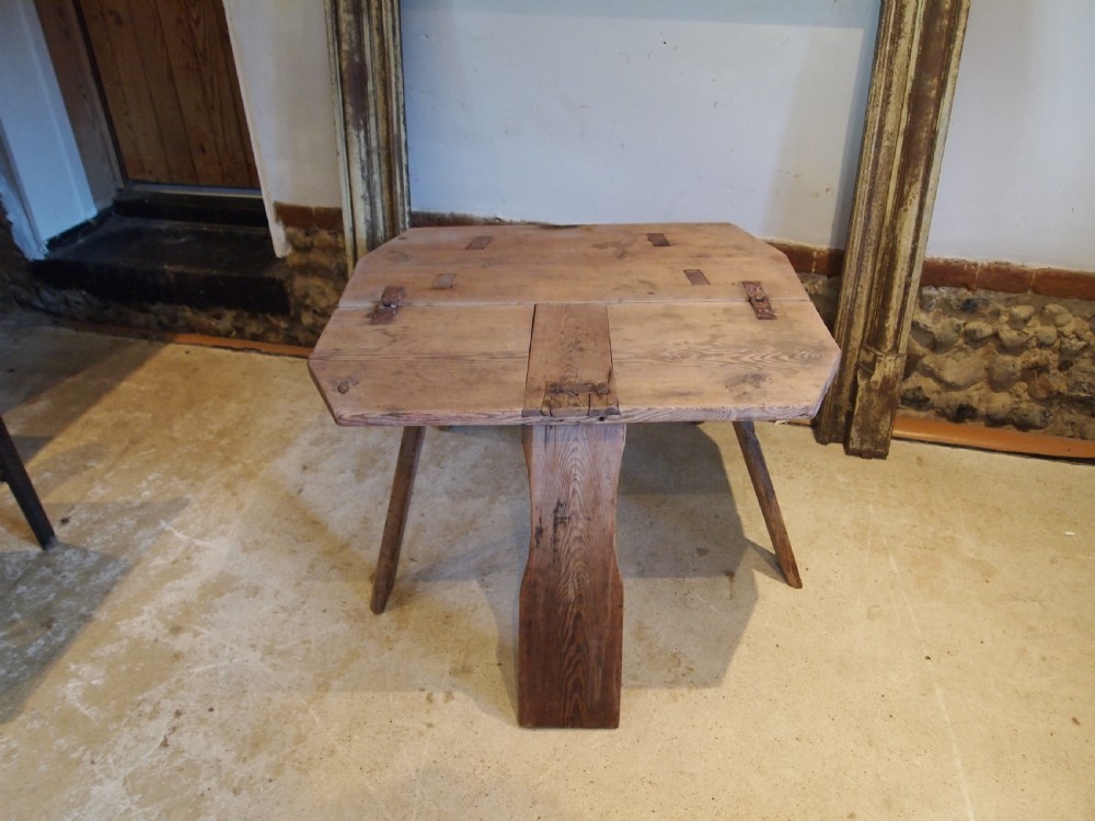 A George III primitive pine chair table featuring a tall central wooden backboard splat, flat bench seat, iron hinges, and four splayed round legs. View IX