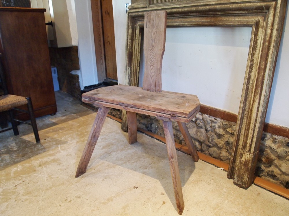 A George III primitive pine chair table featuring a tall central wooden backboard splat, flat bench seat, iron hinges, and four splayed round legs. View XI
