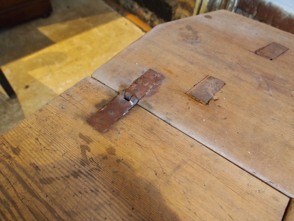 A George III primitive pine chair table featuring a tall central wooden backboard splat, flat bench seat, iron hinges, and four splayed round legs. View XII