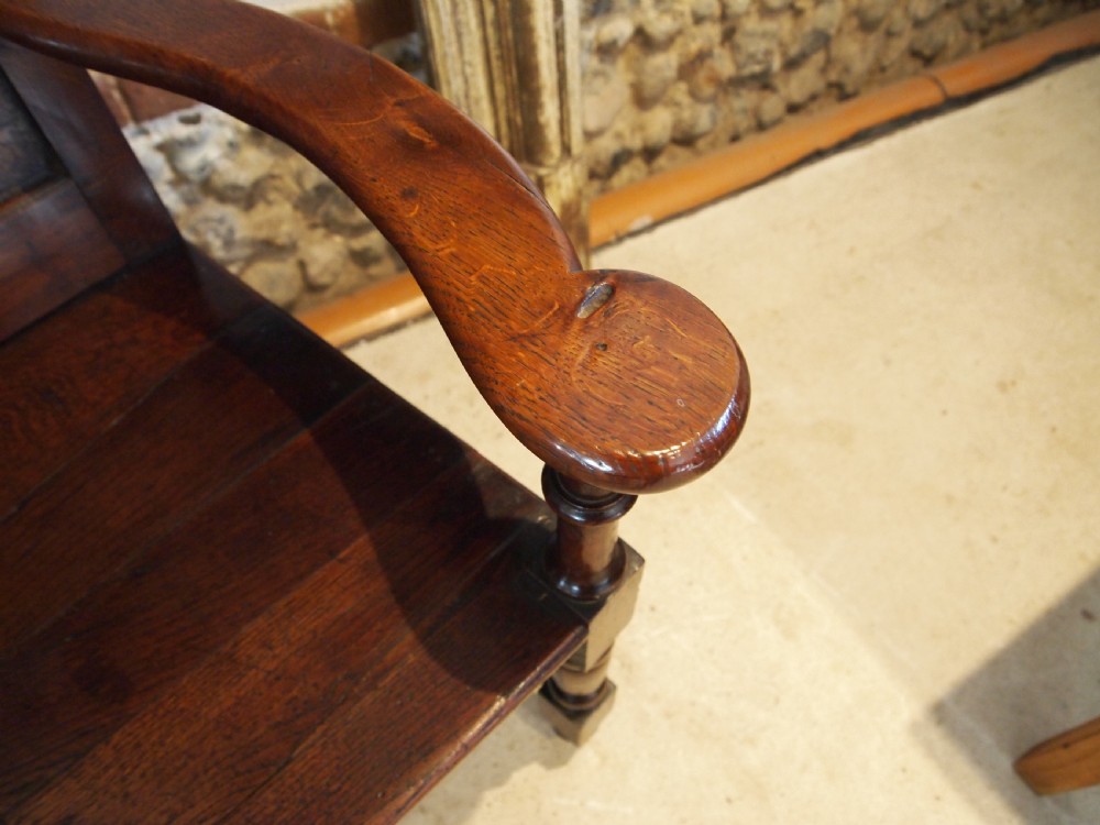 An eighteenth-century dark oak wainscot armchair featuring a panelled backrest, carved finials, turned front legs, and sturdy wooden stretchers. View IX