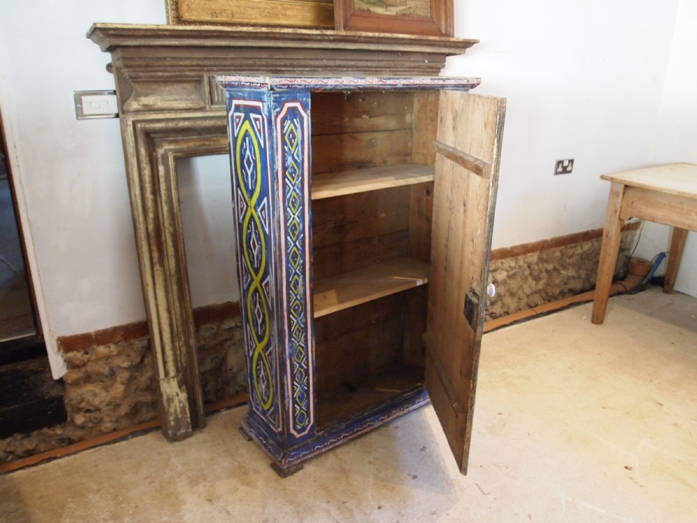 A Victorian pine single-door cupboard decorated with vibrant hand-painted blue, yellow, red, and white geometric folk art motifs. View IV