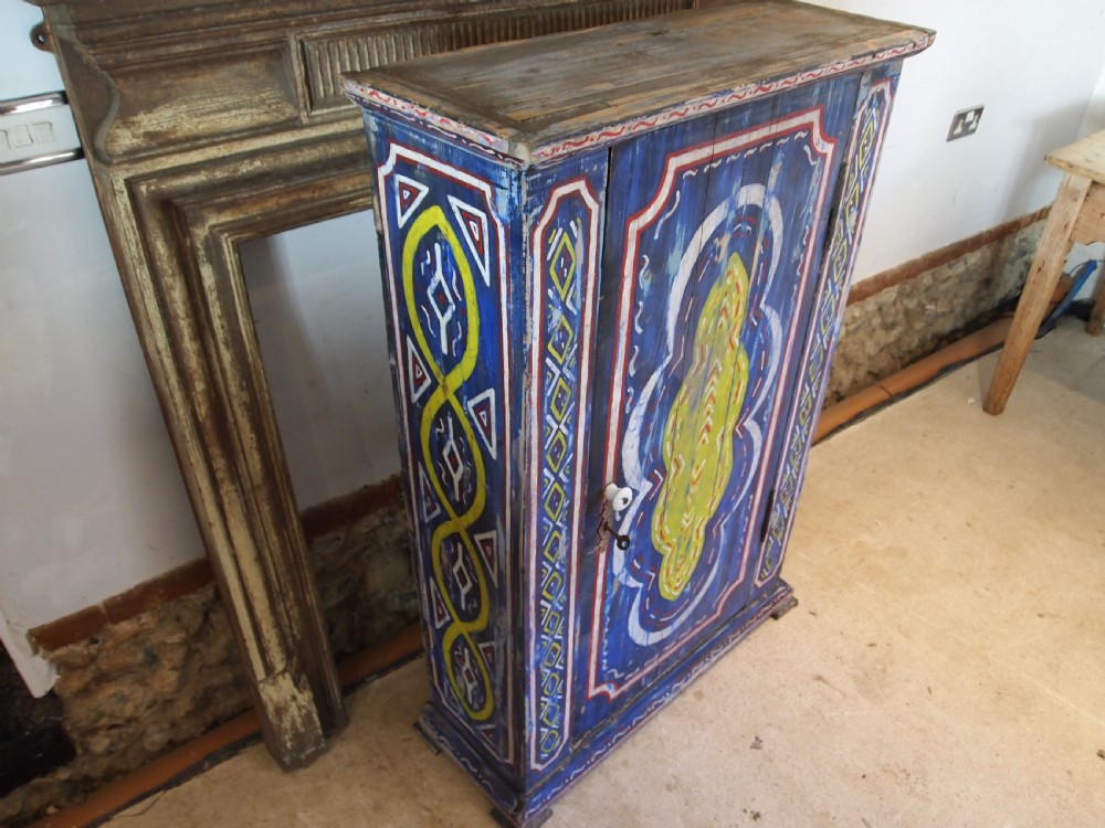 A Victorian pine single-door cupboard decorated with vibrant hand-painted blue, yellow, red, and white geometric folk art motifs. View VIII