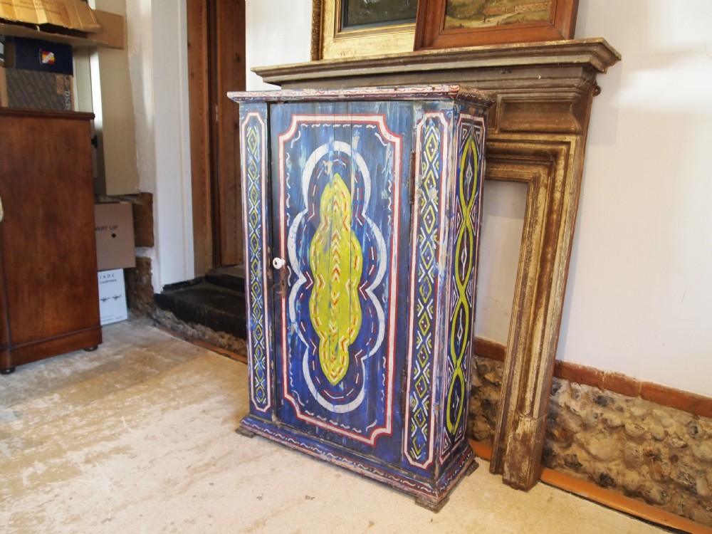A Victorian pine single-door cupboard decorated with vibrant hand-painted blue, yellow, red, and white geometric folk art motifs. View IX