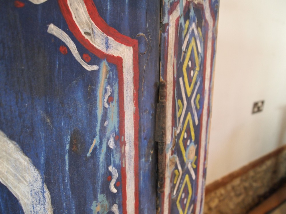 A Victorian pine single-door cupboard decorated with vibrant hand-painted blue, yellow, red, and white geometric folk art motifs. View XII