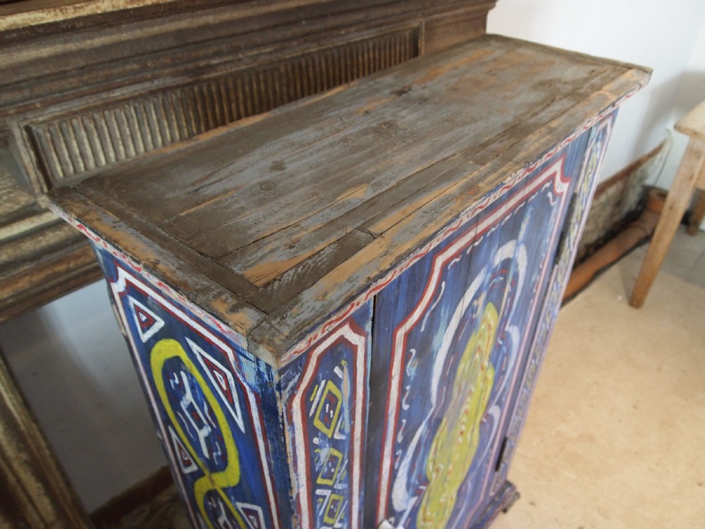 A Victorian pine single-door cupboard decorated with vibrant hand-painted blue, yellow, red, and white geometric folk art motifs. View XIV