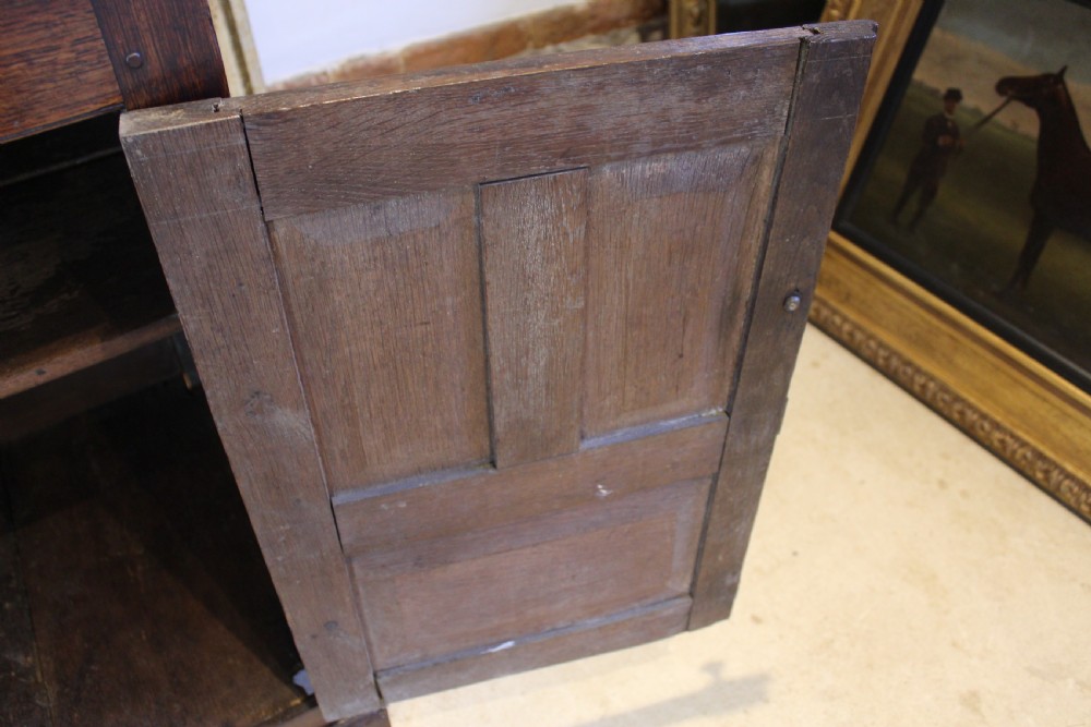 An 18th-century dark oak Welsh Cwpwrdd Deuddarn featuring a two-stage cupboard design with arched panelled upper doors, pendant drop finials, and lower drawers. View VIII