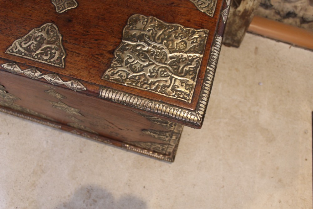 An antique warm brown teak wooden chest adorned with elaborate pierced brass plates, star-shaped metal appliques, and brass stud detailing. View XI