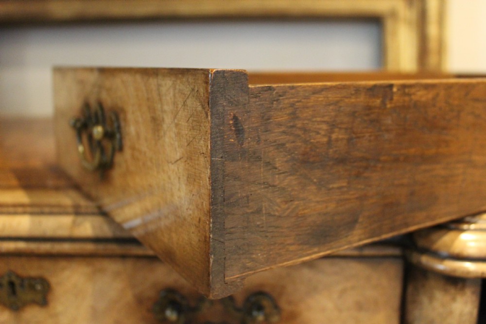An early twentieth-century Queen Anne style burr walnut pedestal desk featuring carved cabriole legs with claw and ball feet, brass handles, and a leather writing surface. View V