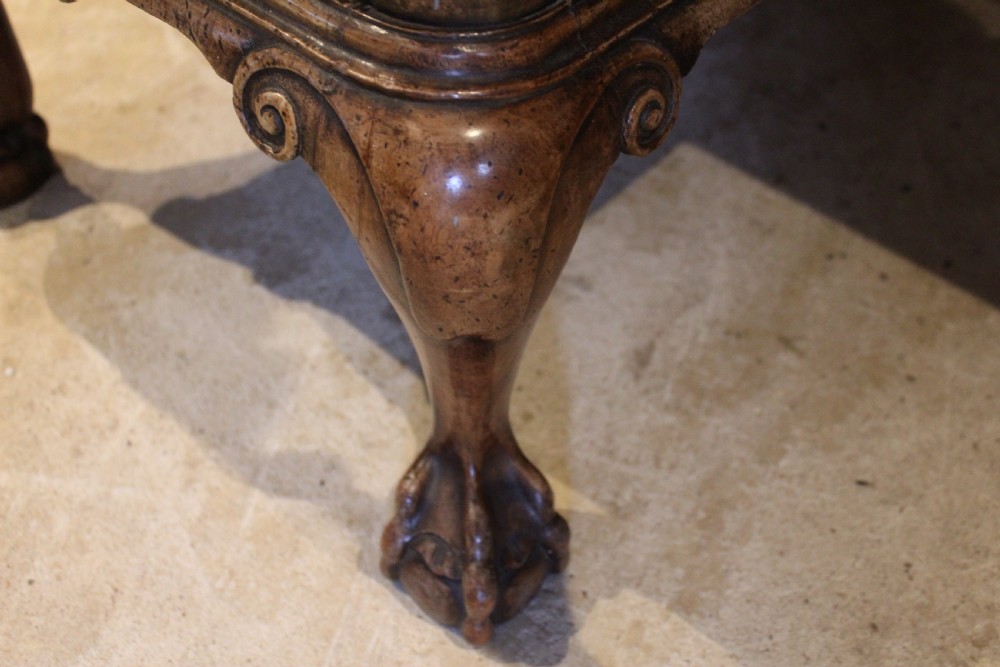 An early twentieth-century Queen Anne style burr walnut pedestal desk featuring carved cabriole legs with claw and ball feet, brass handles, and a leather writing surface. View VII
