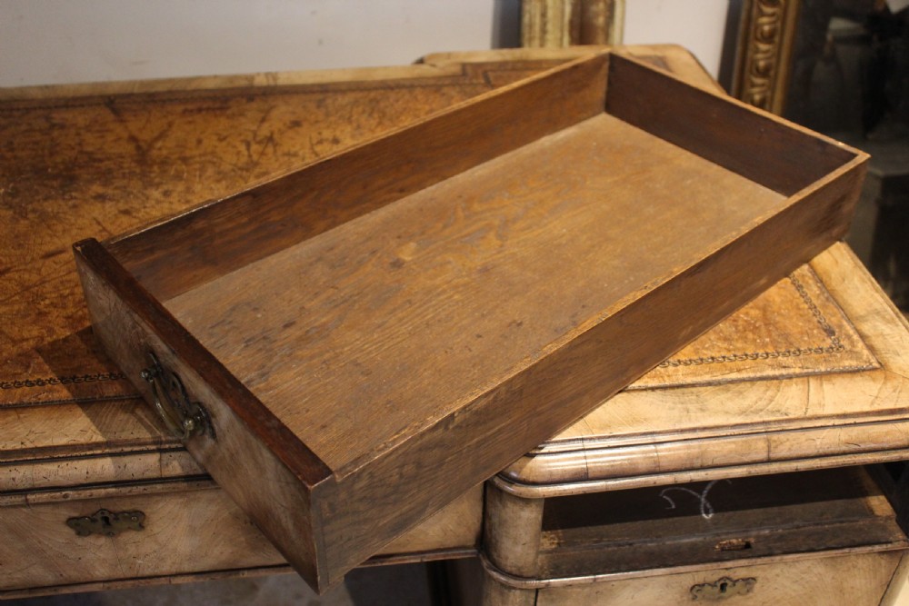An early twentieth-century Queen Anne style burr walnut pedestal desk featuring carved cabriole legs with claw and ball feet, brass handles, and a leather writing surface. View XI
