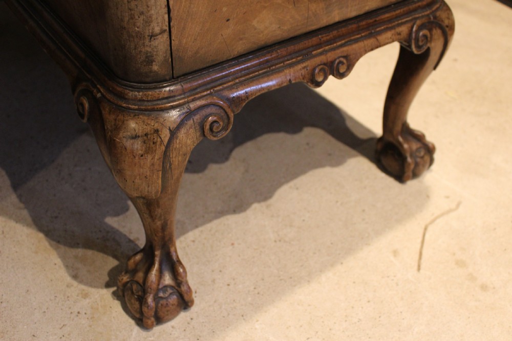 An early twentieth-century Queen Anne style burr walnut pedestal desk featuring carved cabriole legs with claw and ball feet, brass handles, and a leather writing surface. View XV