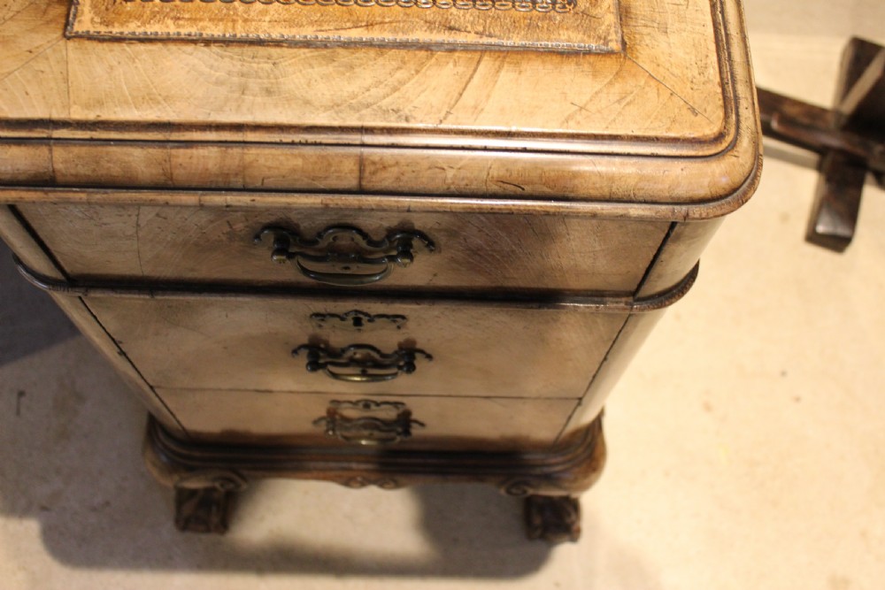 An early twentieth-century Queen Anne style burr walnut pedestal desk featuring carved cabriole legs with claw and ball feet, brass handles, and a leather writing surface. View XVII