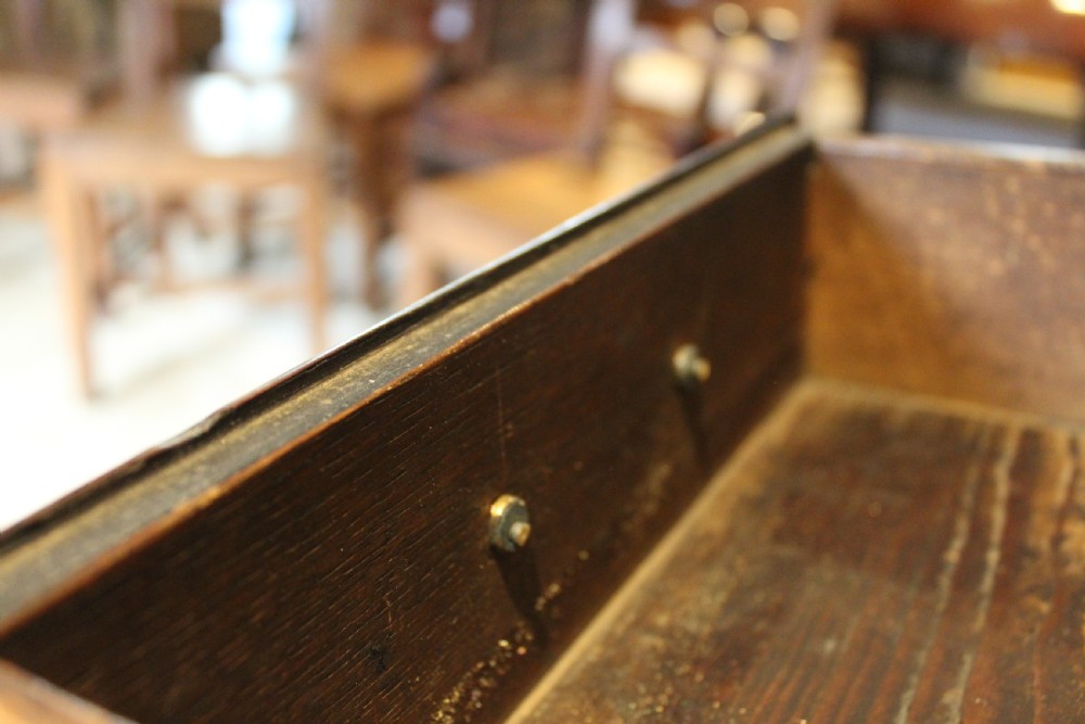 An 18th-century Georgian oak chest of drawers featuring brass swan-neck handles, a central carved arch door, and bracket feet. View IX