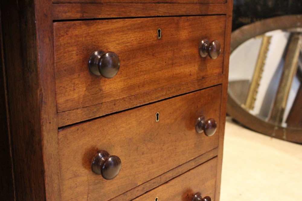 A Victorian mahogany pedestal desk fitted with a central hinged writing slope, leather top inserts, and graduated drawers with turned wooden handles. View XI