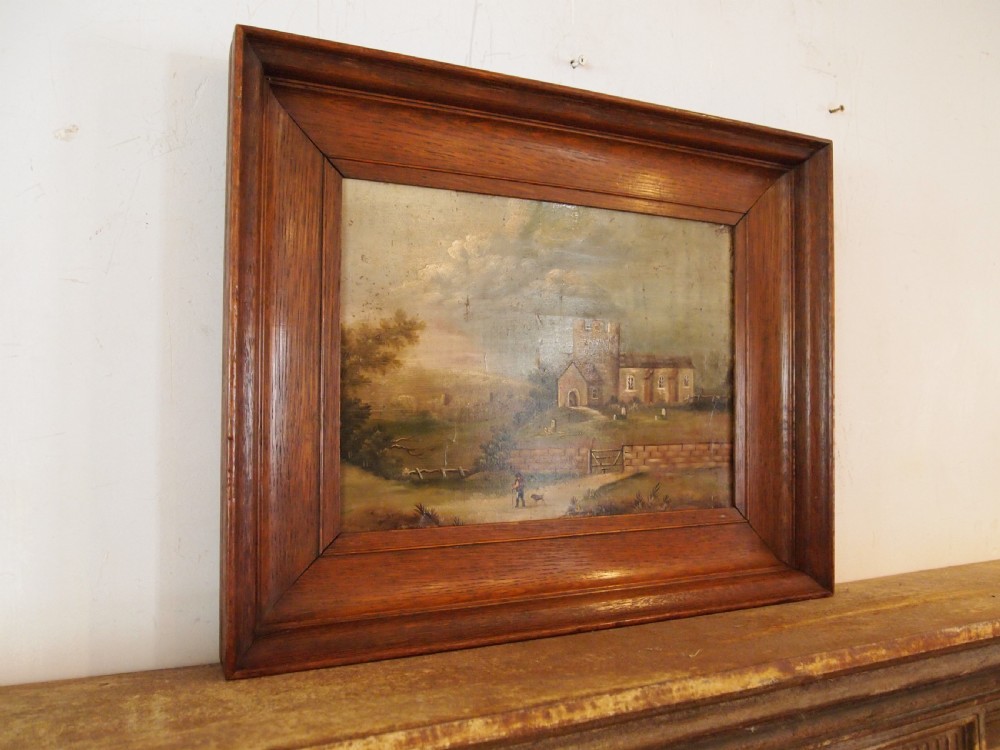 A 19th-century naive oil painting on board depicting a rural church scene with a figure walking a dog, set within a wide wooden frame. View III