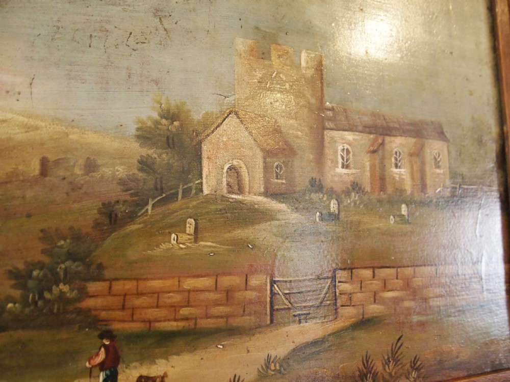 A 19th-century naive oil painting on board depicting a rural church scene with a figure walking a dog, set within a wide wooden frame. View IX