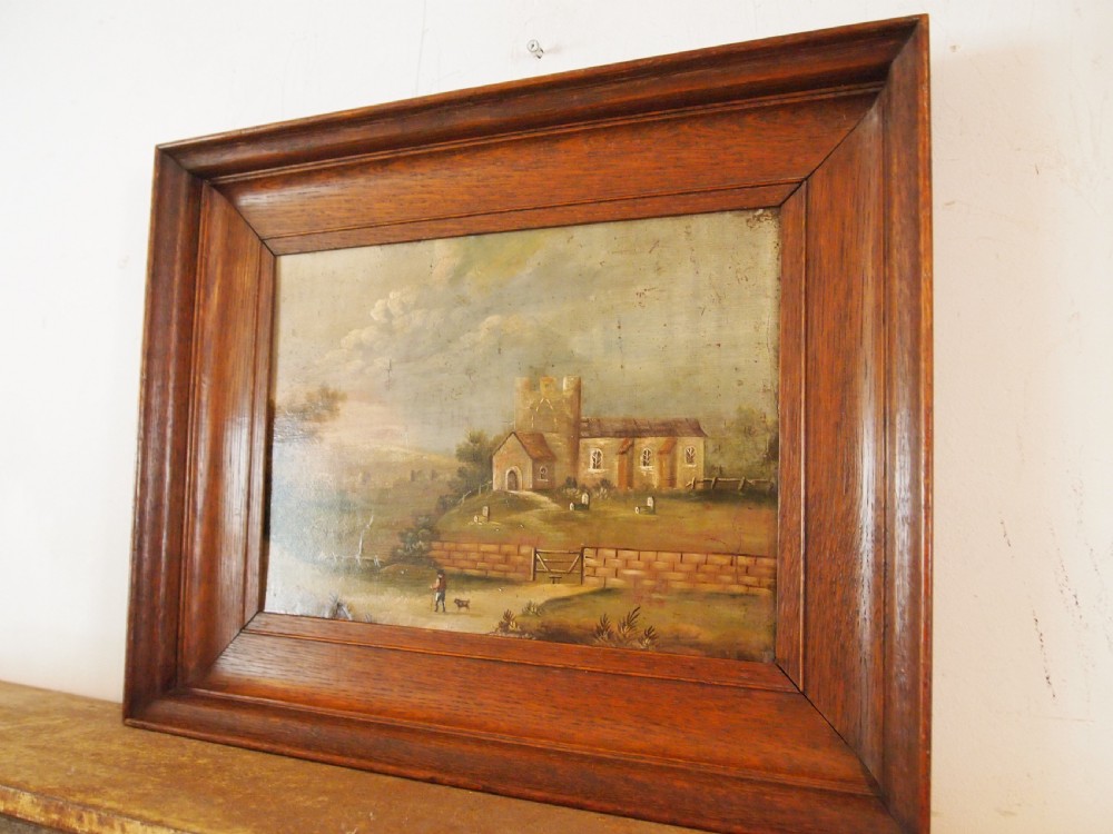 A 19th-century naive oil painting on board depicting a rural church scene with a figure walking a dog, set within a wide wooden frame. View XI