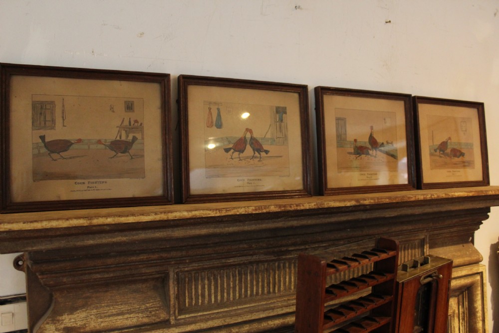 A set of four framed Victorian aquatint prints depicting cockfighting scenes in matching dark wood frames.