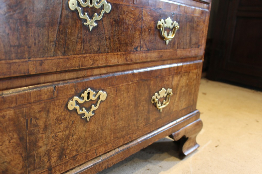 A George II walnut bureau featuring a slanted fall-front flap over four graduated drawers with brass handles, resting on bracket feet. View VII