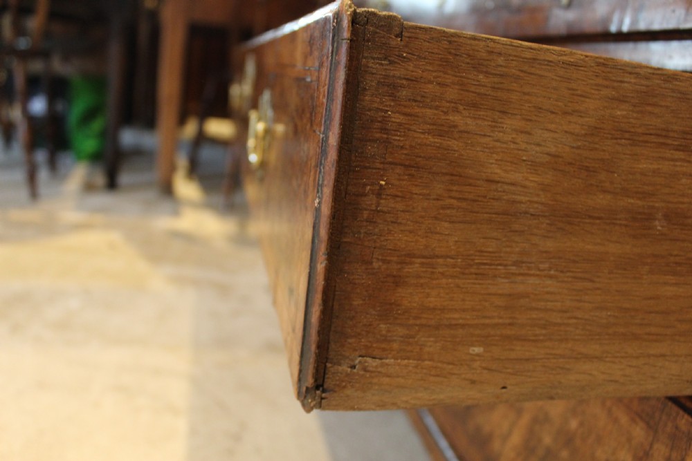 A George II walnut bureau featuring a slanted fall-front flap over four graduated drawers with brass handles, resting on bracket feet. View IX
